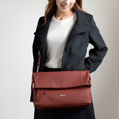japanese women looking down at red shrink leather bag