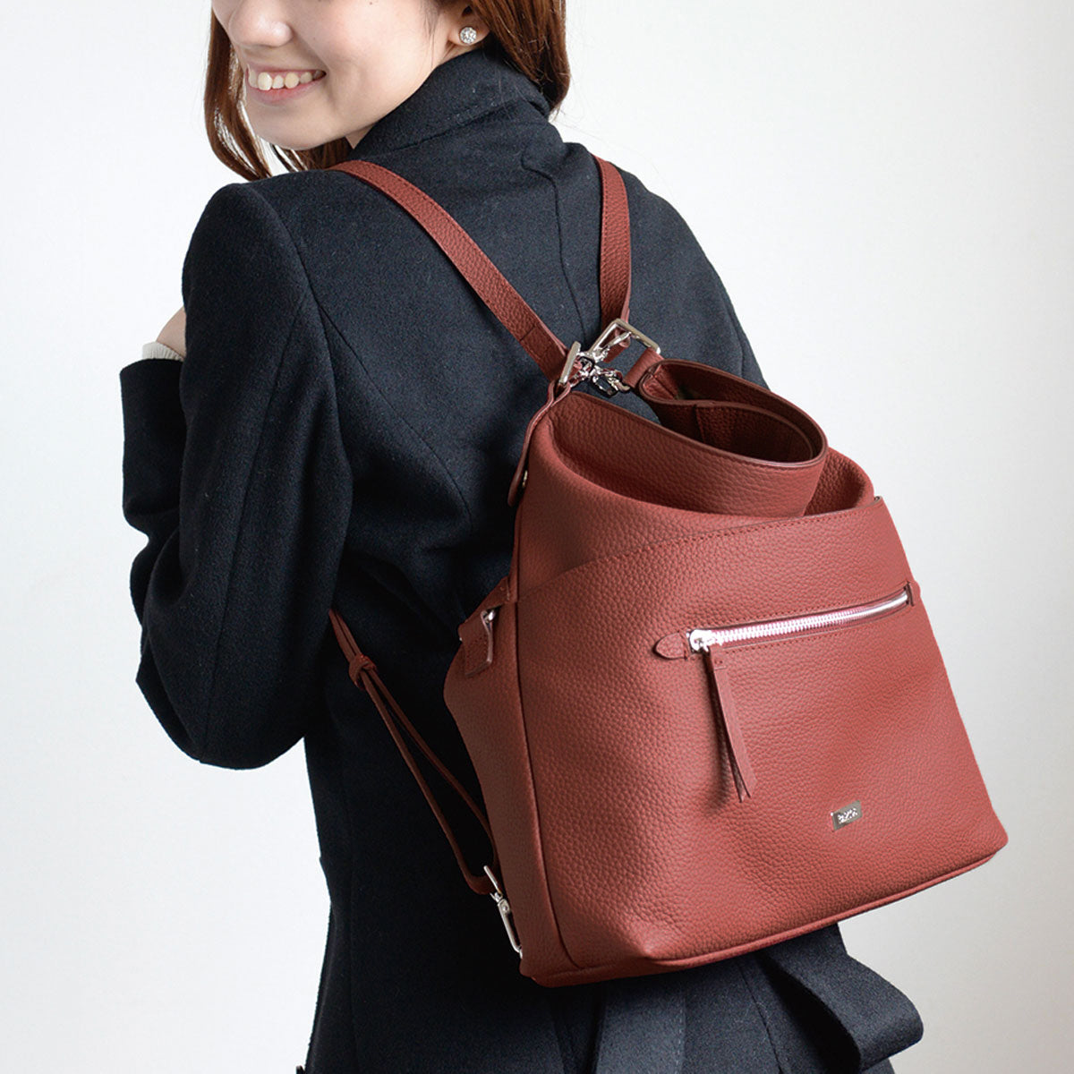 smiling japanese women carrying red leather backpack